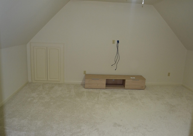 bonus room with lofted ceiling and light colored carpet