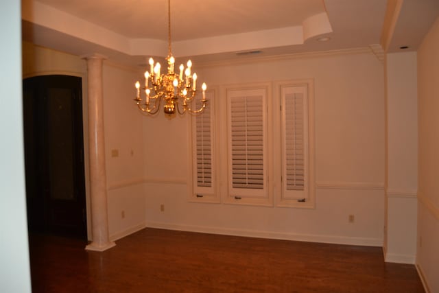 unfurnished room with dark wood-type flooring, decorative columns, crown molding, a notable chandelier, and a raised ceiling