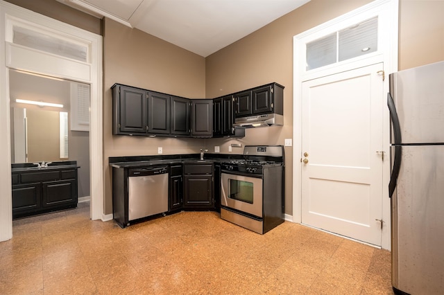 376 Mulberry St, Memphis, TN 38103 - kitchen with dark countertops, a sink, under cabinet range hood, light floors, and stainless steel appliances