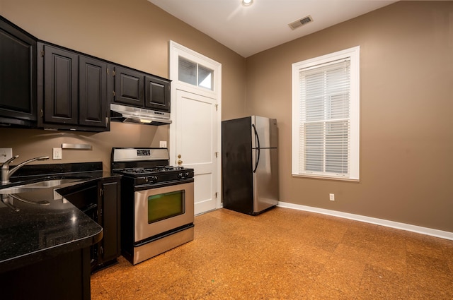 376 Mulberry St, Memphis, TN 38103 - kitchen with visible vents, baseboards, under cabinet range hood, dark cabinets, and stainless steel appliances