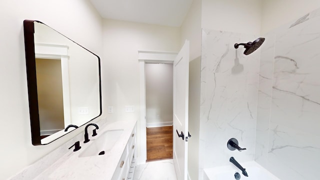 bathroom featuring wood-type flooring, vanity, and tiled shower / bath