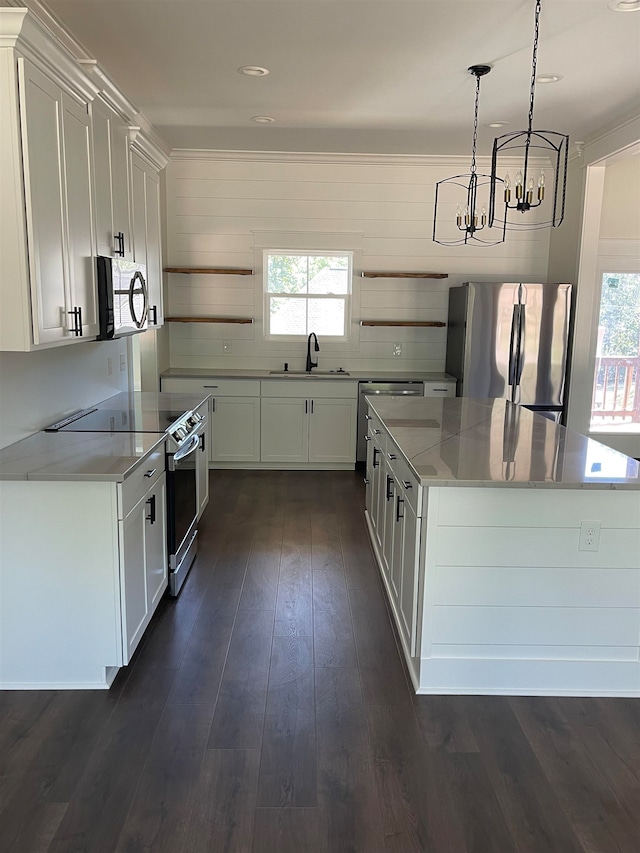 kitchen featuring white cabinets, dark wood-style floors, a center island, stainless steel appliances, and a sink