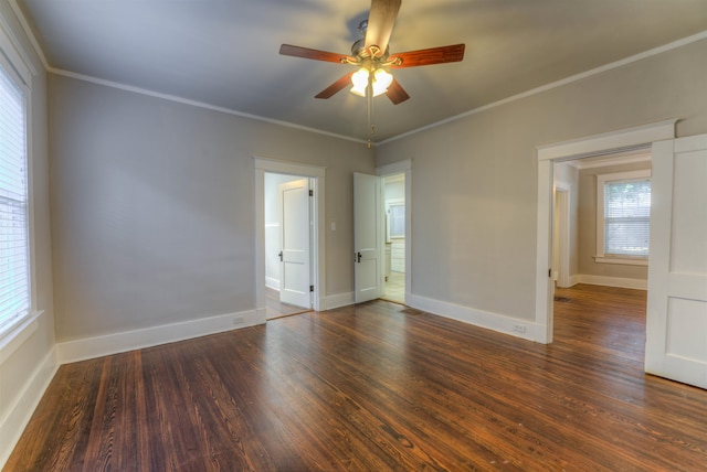 empty room featuring ornamental molding, dark wood-type flooring, and ceiling fan