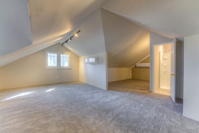 bonus room with lofted ceiling, a wall mounted air conditioner, and light colored carpet