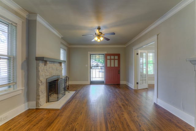 unfurnished living room with a stone fireplace, dark hardwood / wood-style floors, a healthy amount of sunlight, and ceiling fan