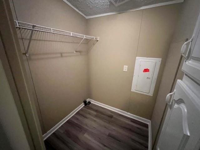 clothes washing area with ornamental molding, electric panel, and dark hardwood / wood-style floors