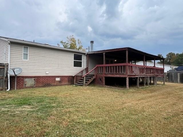 back of property featuring a wooden deck and a yard