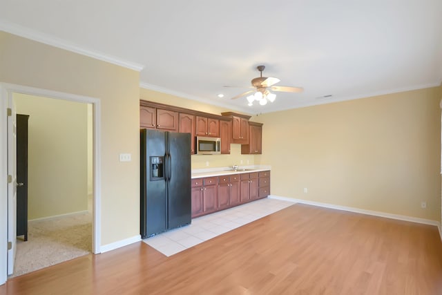 kitchen with light hardwood / wood-style floors, ceiling fan, sink, and black fridge