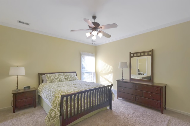 bedroom featuring ceiling fan, crown molding, and light colored carpet