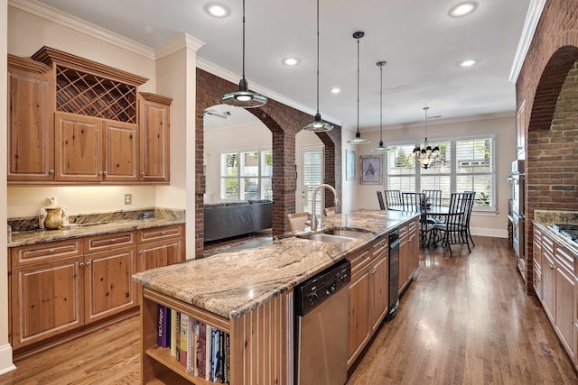 kitchen with a center island with sink, decorative light fixtures, stainless steel appliances, and a healthy amount of sunlight