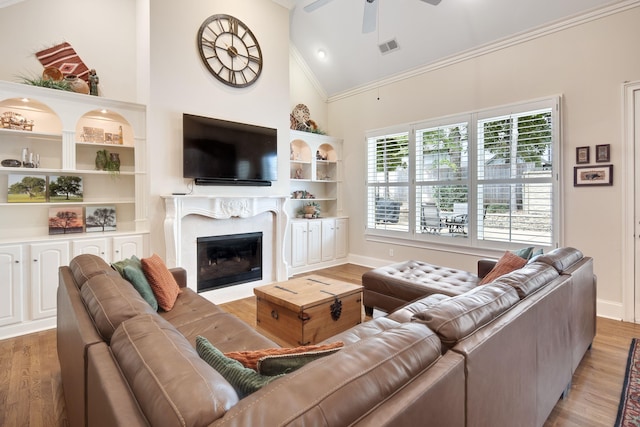 living room with ornamental molding, high vaulted ceiling, wood-type flooring, and ceiling fan