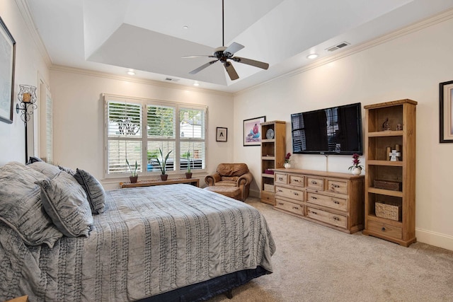 carpeted bedroom with ornamental molding, a tray ceiling, and ceiling fan