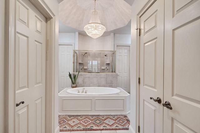 bathroom with a notable chandelier and shower with separate bathtub