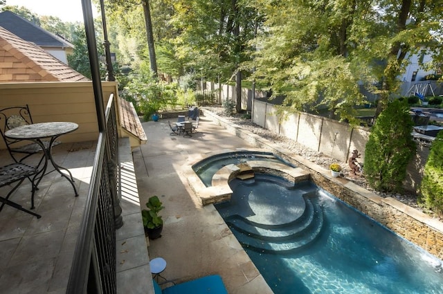 view of swimming pool featuring an in ground hot tub and a patio area