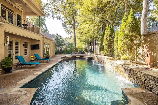 view of swimming pool with an in ground hot tub, pool water feature, a patio area, and french doors