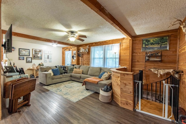 living room featuring wood walls, dark hardwood / wood-style floors, and a textured ceiling