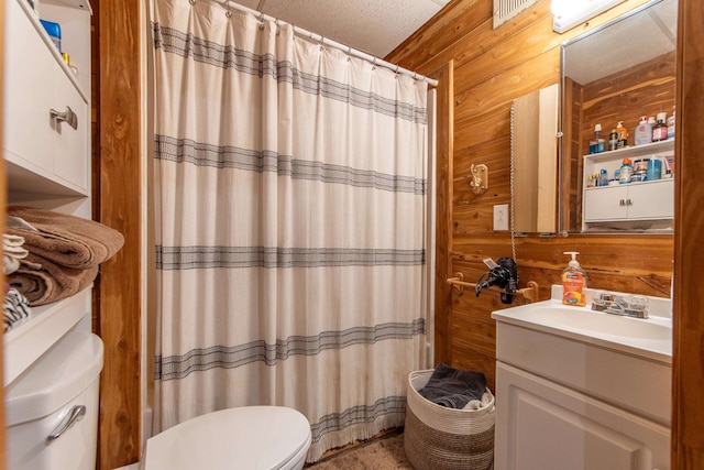 bathroom with toilet, curtained shower, vanity, a textured ceiling, and wood walls