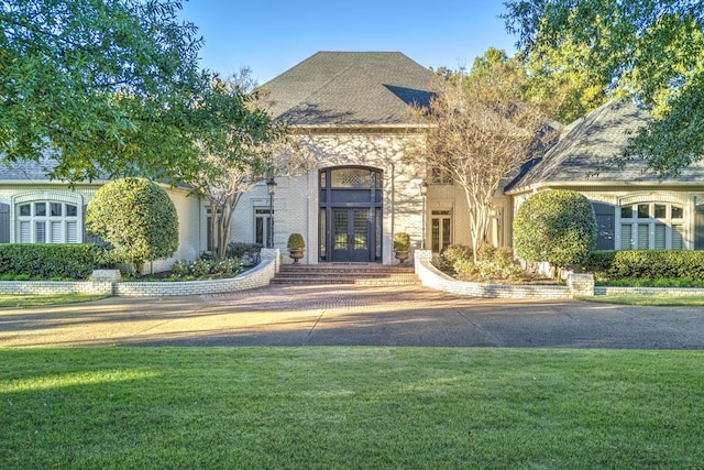 view of front of property with french doors and a front lawn