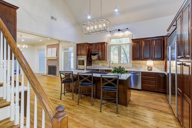 kitchen with a breakfast bar, a center island, light hardwood / wood-style flooring, and stainless steel appliances