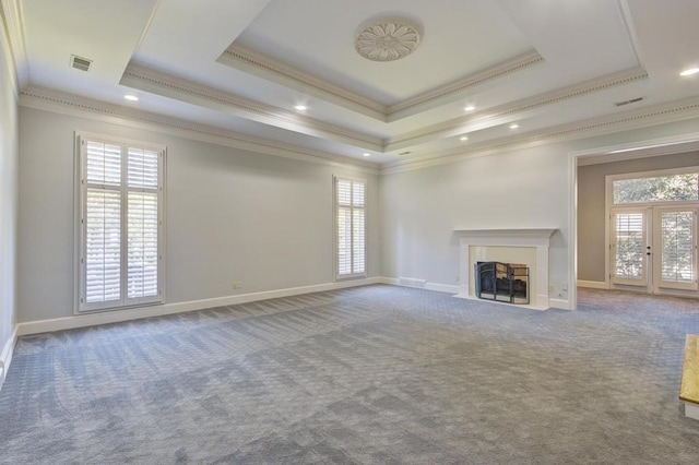 unfurnished living room with french doors, crown molding, a raised ceiling, and carpet floors