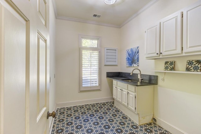 kitchen featuring ornamental molding, sink, and white cabinetry