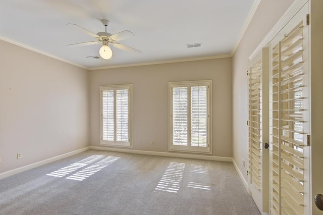 empty room featuring light carpet, ornamental molding, plenty of natural light, and ceiling fan