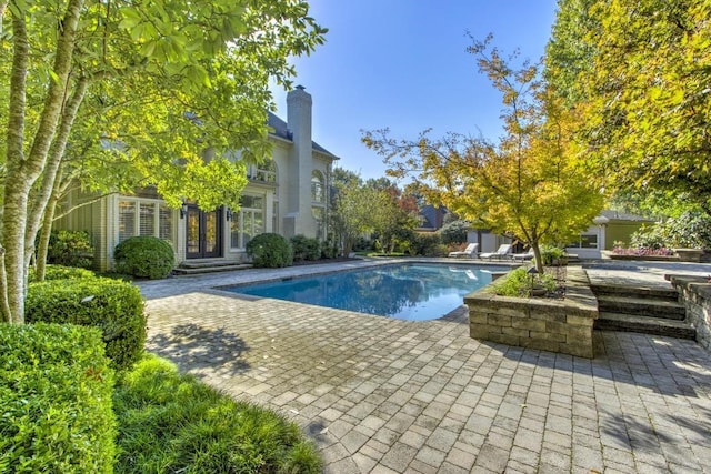 view of pool with french doors and a patio