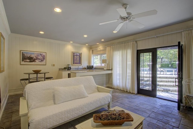 living room featuring ornamental molding, wood-type flooring, and ceiling fan