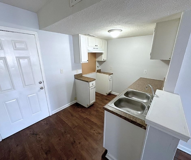 kitchen featuring a textured ceiling, white cabinetry, sink, and dark hardwood / wood-style floors