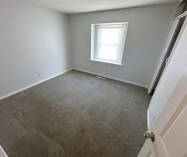 carpeted spare room featuring a textured ceiling