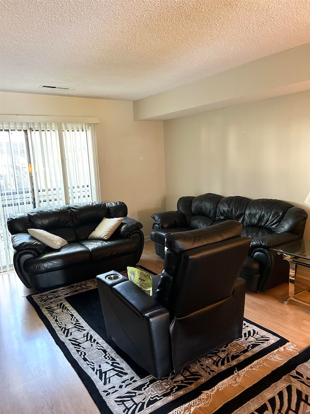 living room with hardwood / wood-style floors and a textured ceiling