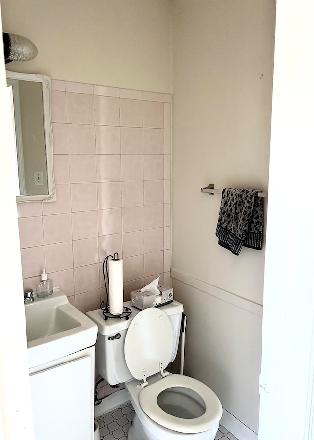 bathroom with vanity, toilet, tile patterned floors, and tile walls