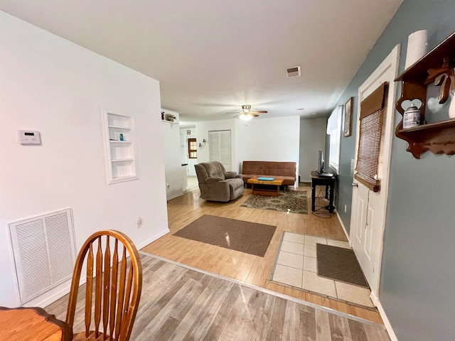 living room with light hardwood / wood-style flooring and ceiling fan