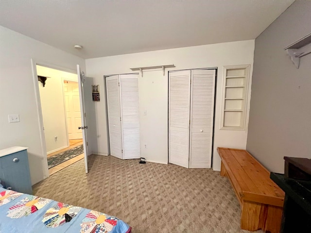 bedroom featuring two closets and light colored carpet