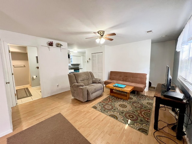 living room with light wood-type flooring and ceiling fan