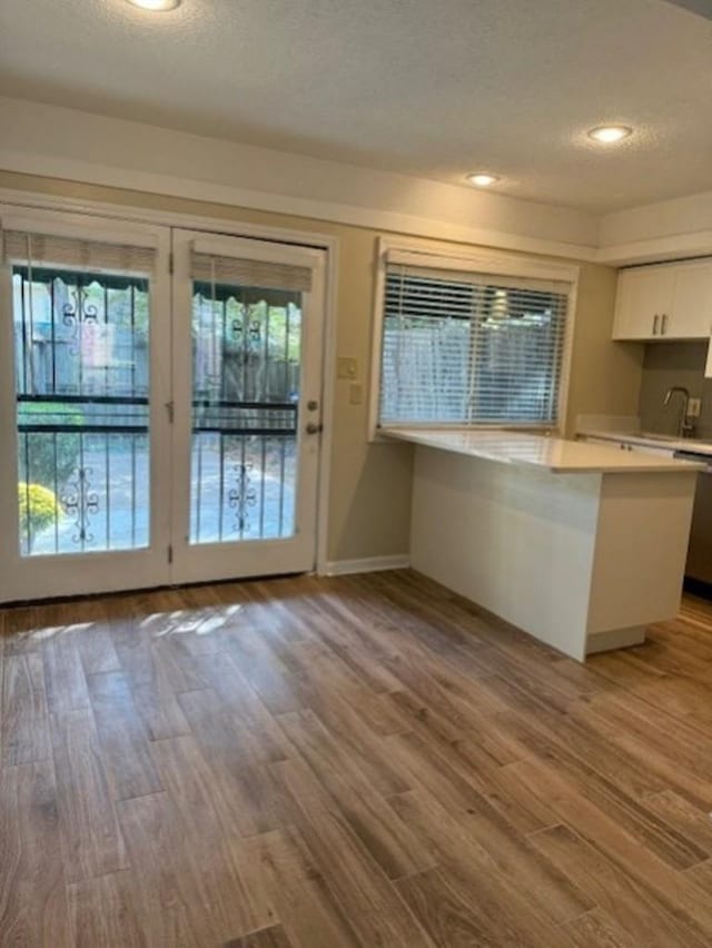 1231 Chamberlain Dr Unit 1231, Memphis, TN 38119 - kitchen with a textured ceiling, wood finished floors, light countertops, white cabinets, and a peninsula