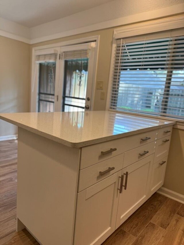 1231 Chamberlain Dr Unit 1231, Memphis, TN 38119 - kitchen featuring white cabinets, dark wood-style flooring, light stone countertops, baseboards, and a kitchen island