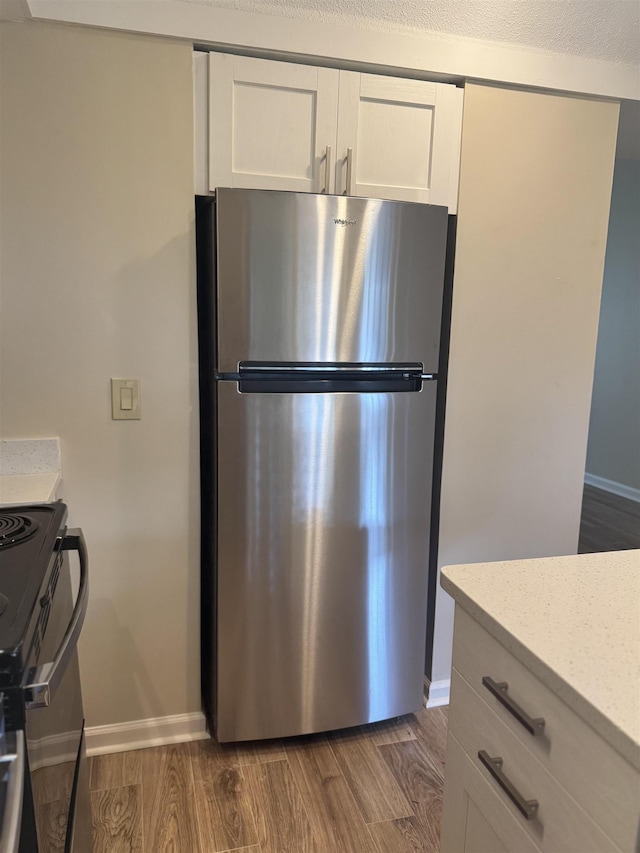 1231 Chamberlain Dr Unit 1231, Memphis, TN 38119 - kitchen with freestanding refrigerator, baseboards, stove, and dark wood-type flooring