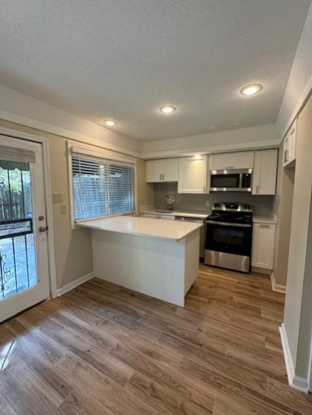 1231 Chamberlain Dr Unit 1231, Memphis, TN 38119 - kitchen with dark wood-style flooring, a textured ceiling, appliances with stainless steel finishes, and white cabinets
