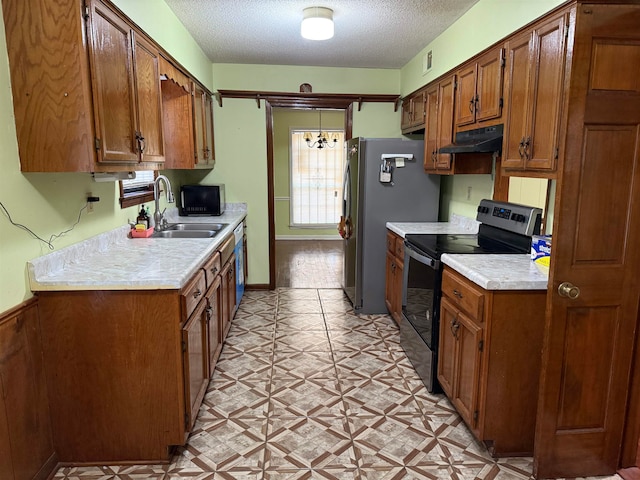 kitchen with sink, appliances with stainless steel finishes, a textured ceiling, and a chandelier