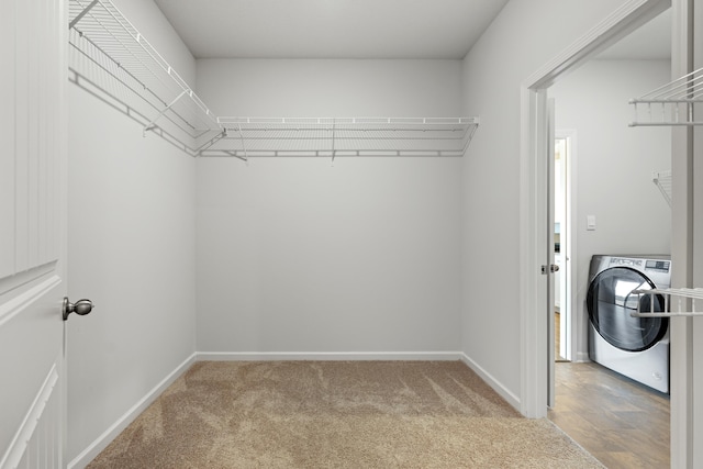 walk in closet with washer / clothes dryer and carpet floors