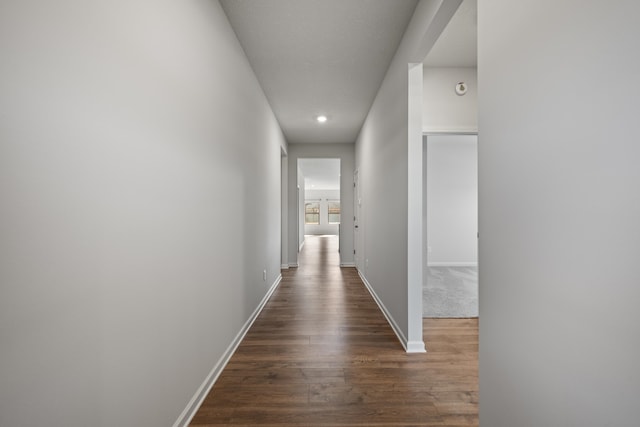 corridor with dark hardwood / wood-style flooring