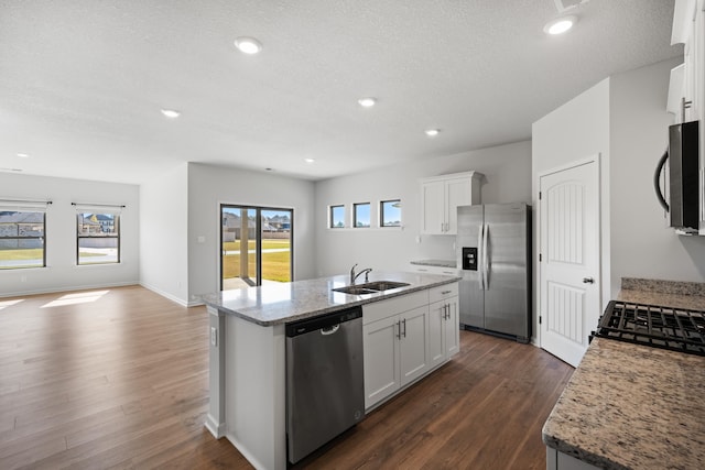 kitchen with a kitchen island with sink, stainless steel appliances, and white cabinets