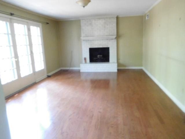 unfurnished living room featuring hardwood / wood-style flooring and a fireplace