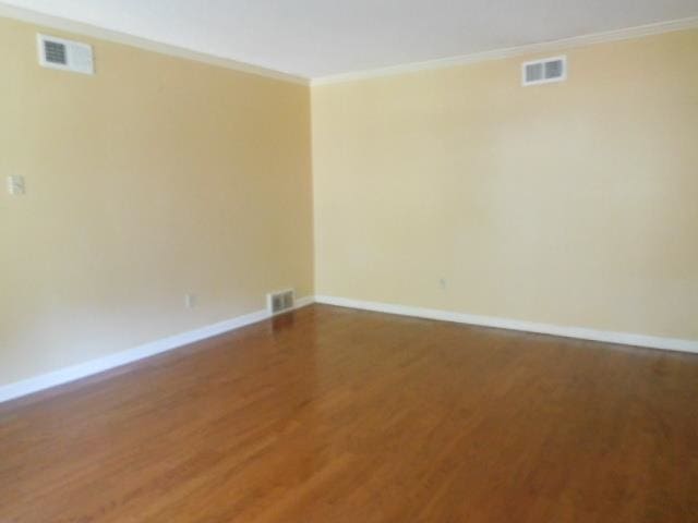 unfurnished room with ornamental molding and hardwood / wood-style floors