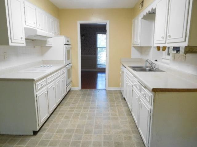 kitchen with white cabinetry, tasteful backsplash, sink, and white appliances