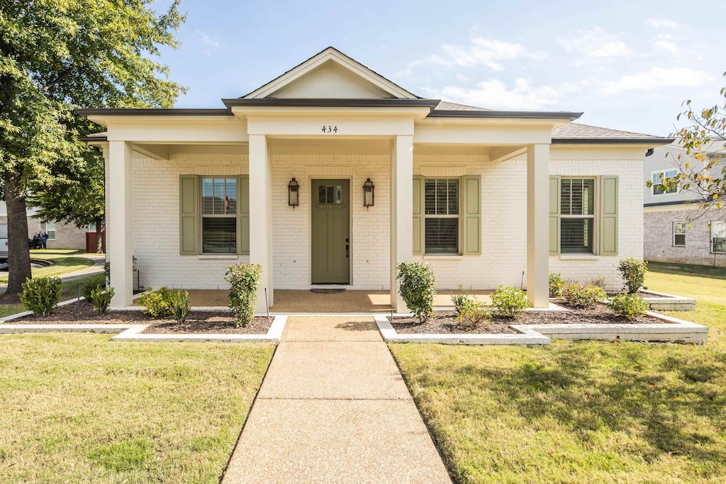 view of front facade with a front yard and covered porch