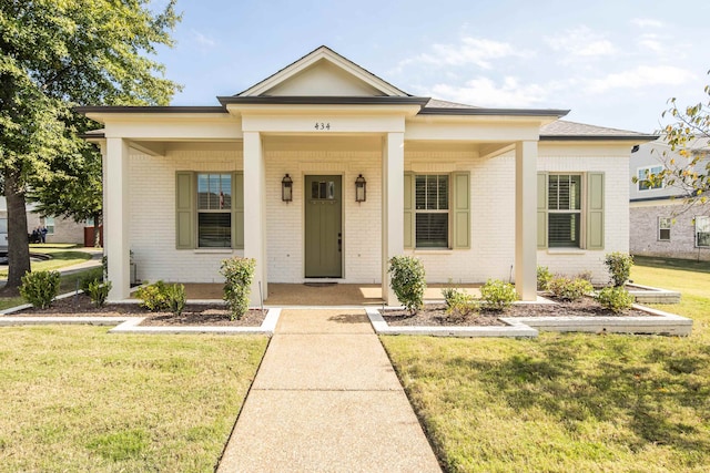 view of front facade with a front yard and covered porch