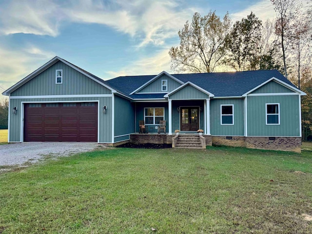 view of front of property featuring a garage, a porch, and a front lawn