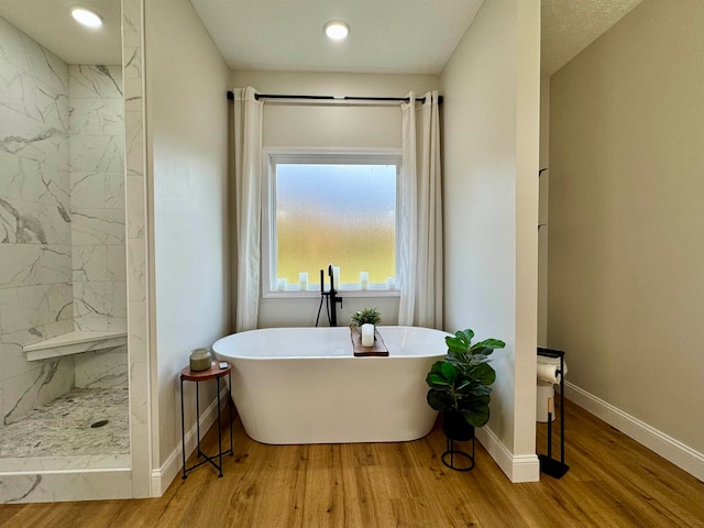 bathroom with plus walk in shower and hardwood / wood-style flooring